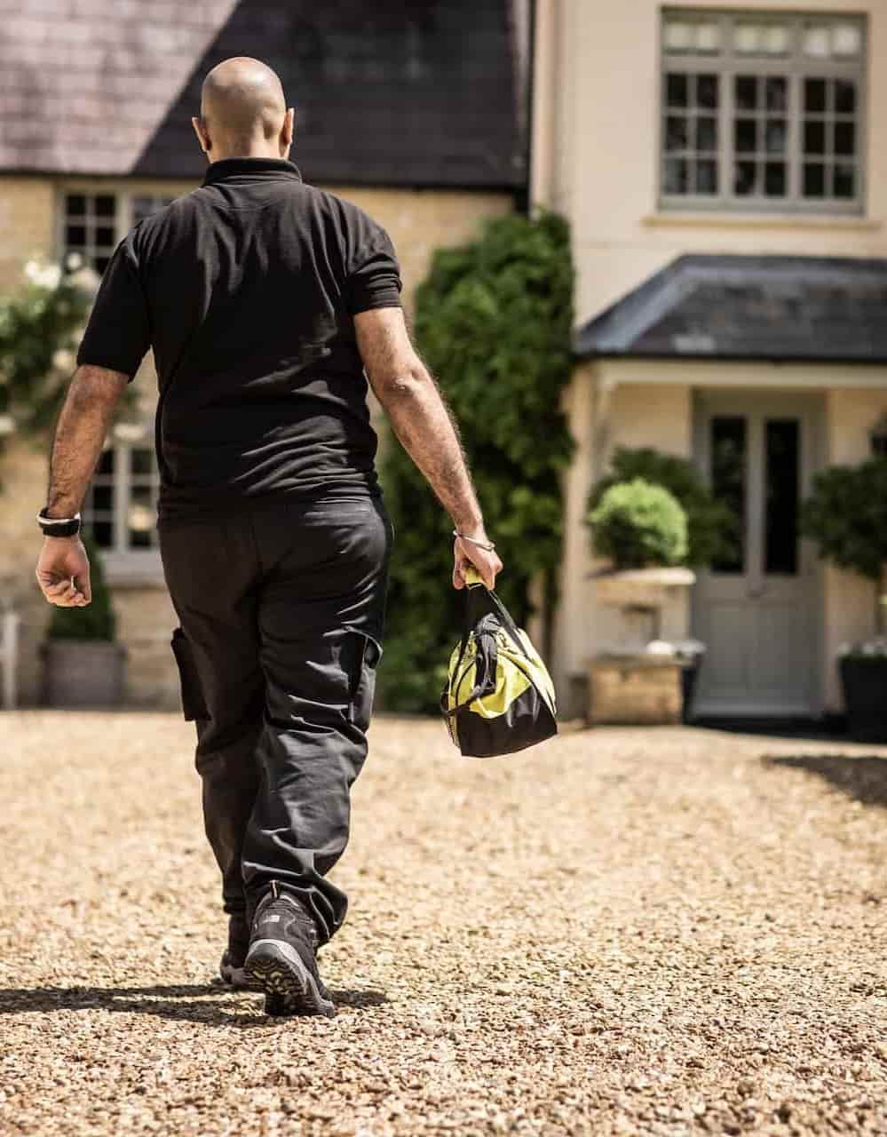 LPG Gas Engineer walking towards a house with his tool bag