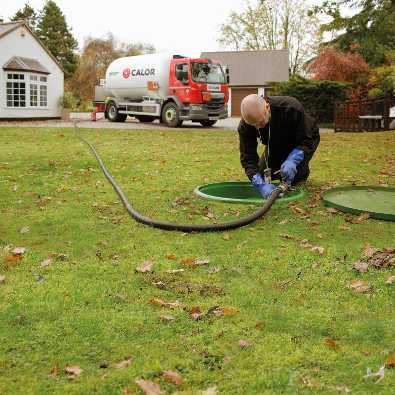 A Calor employee filling an underground tank with LPG