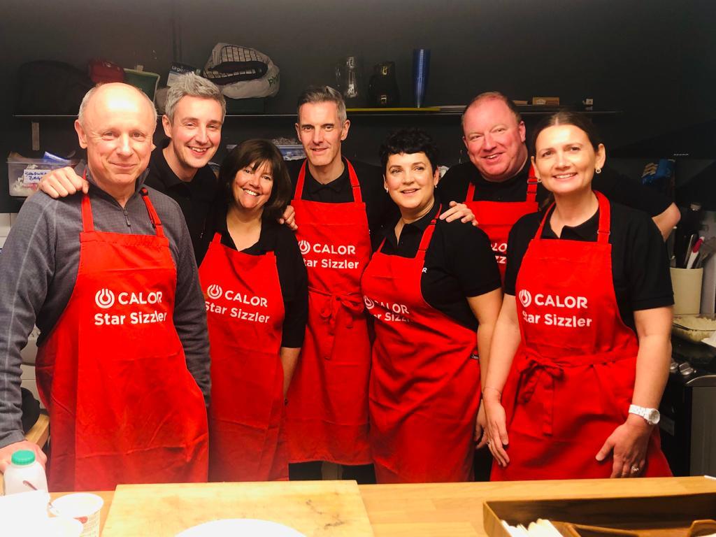 The Calor Management team in red aprons at helping hands soup kitchen