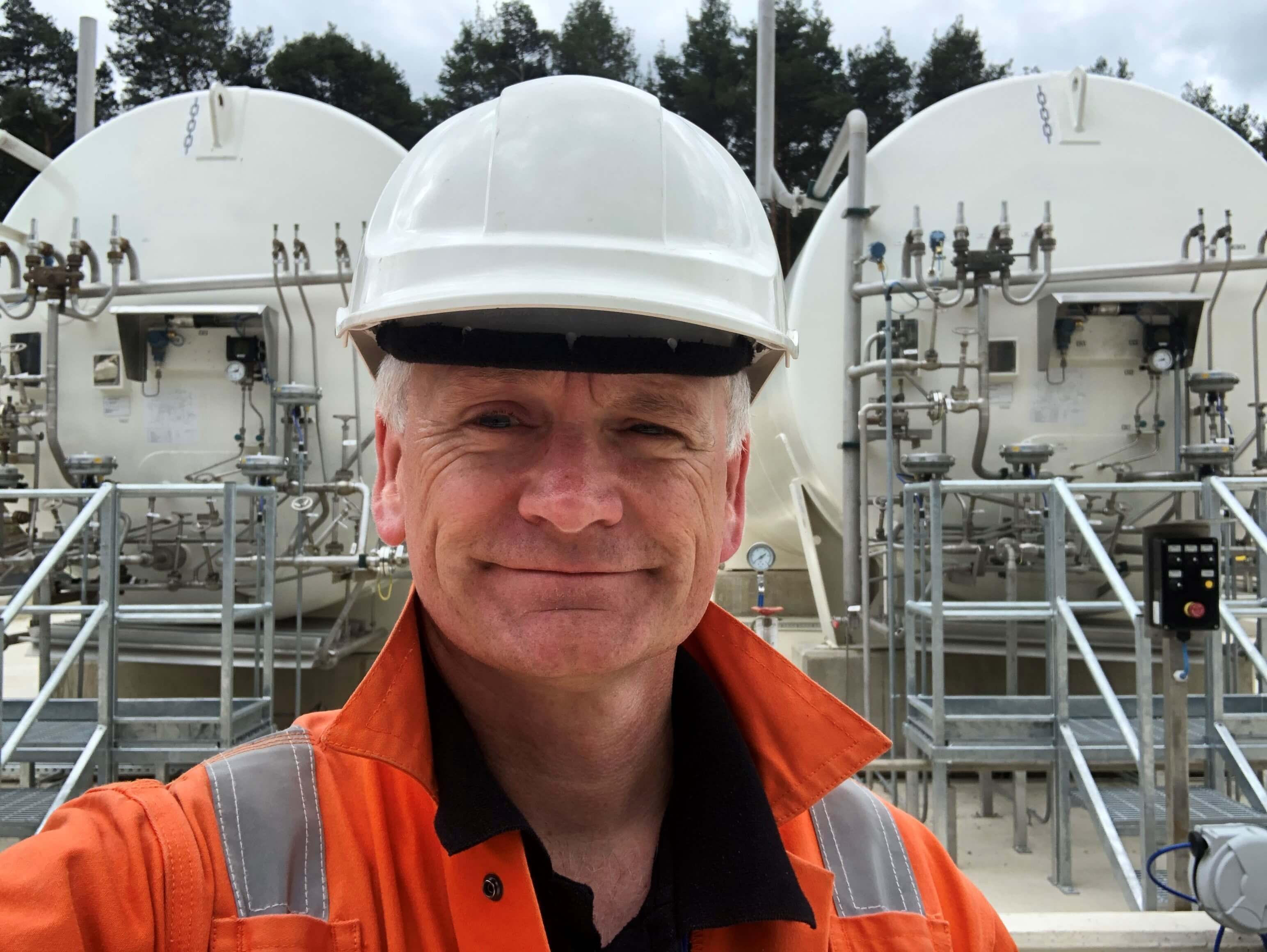 Calor employee Paul Smith wearing a high vis jacket and hard hat outside a Calor plant 