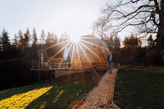 The fold and a cabin with the sun shining with owner in the image. 