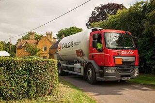 A Calor lorry driving on a narrow road in a rural village